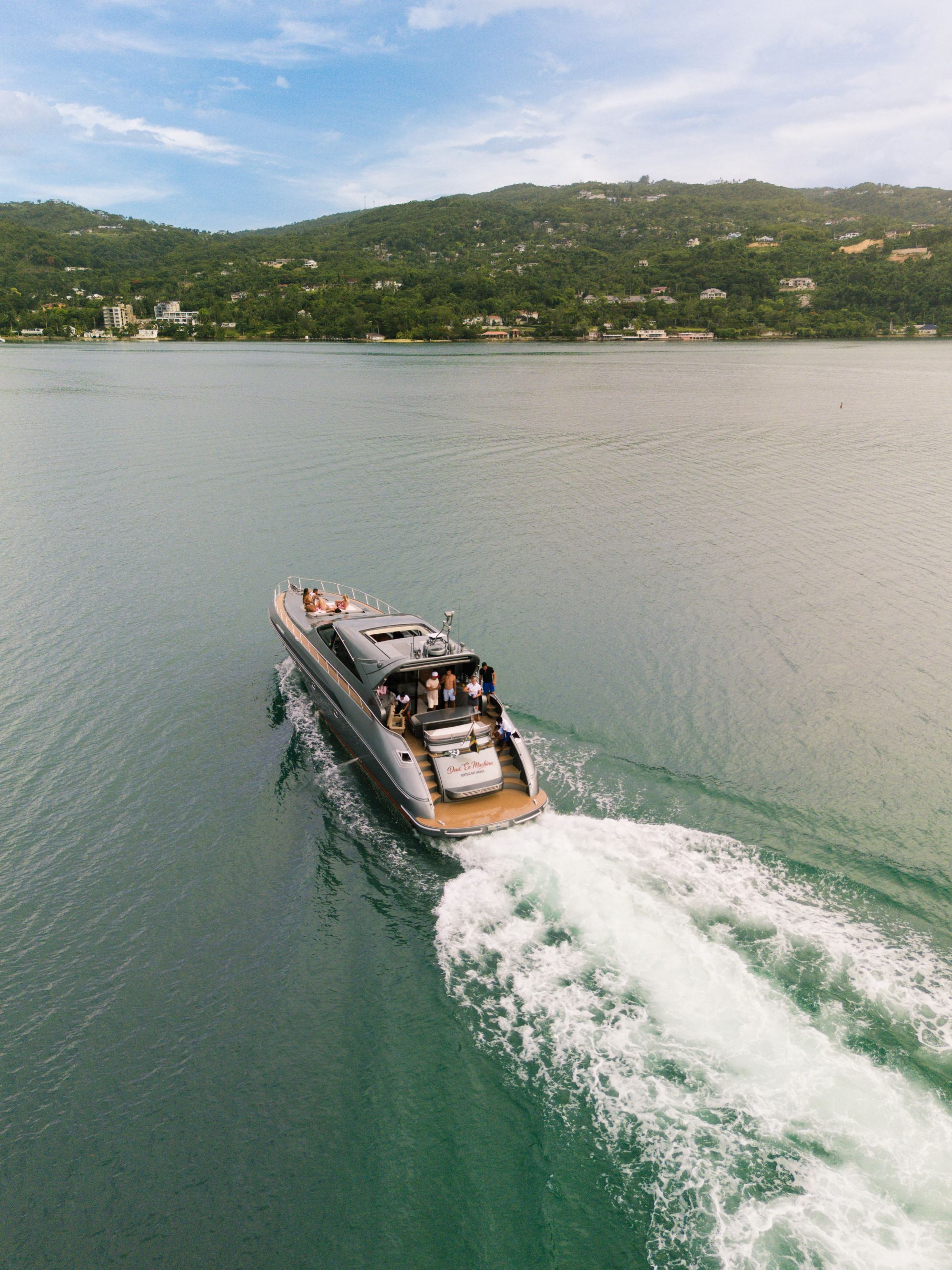 Aerial of a tender running in along a green coastline