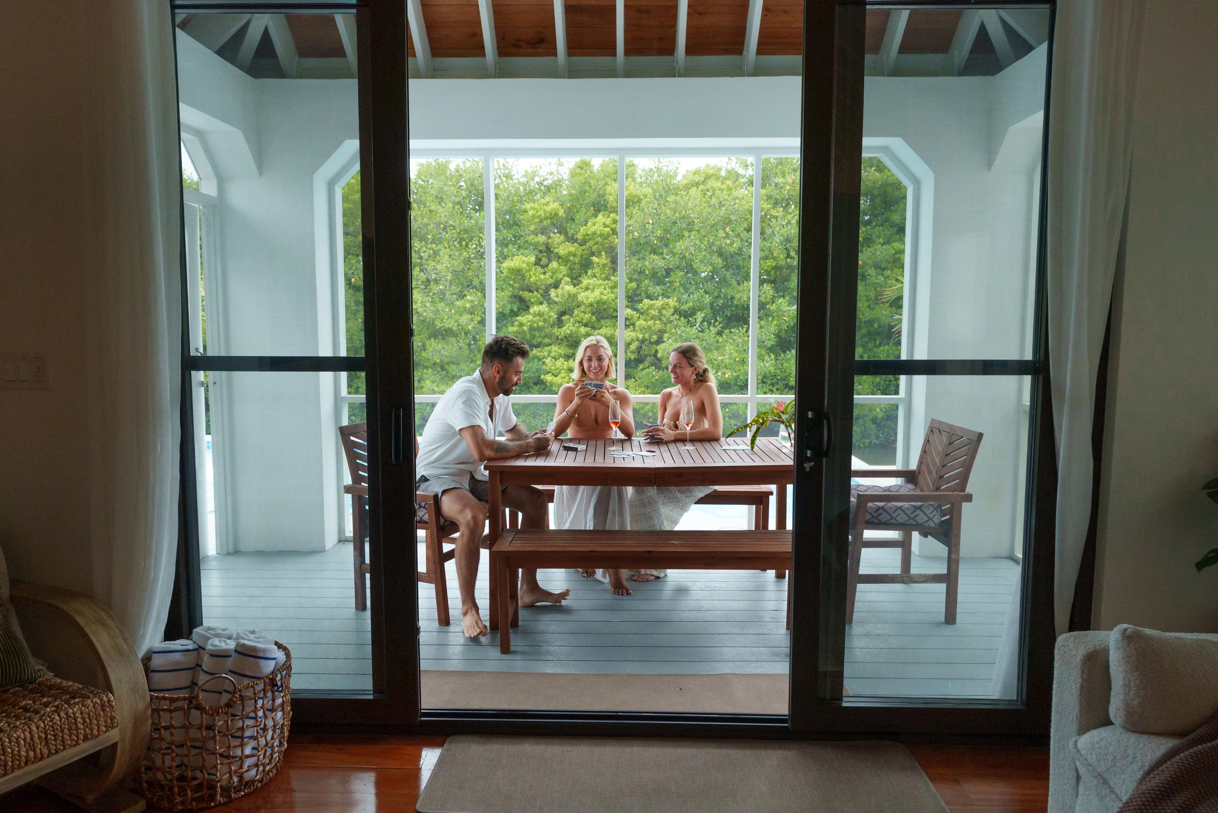 Guests at the table on the terrace, seen from inside the villa